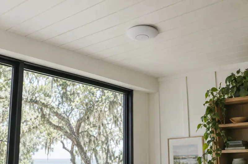 Illustrative photo: a ceiling-mounted wireless access point in a bright office